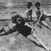 Circa 1925: Five women at the beach posing in their swimming costumes.