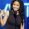 Nicki Minaj points to herself, smiling in self-celebration, because she is a true heroine.